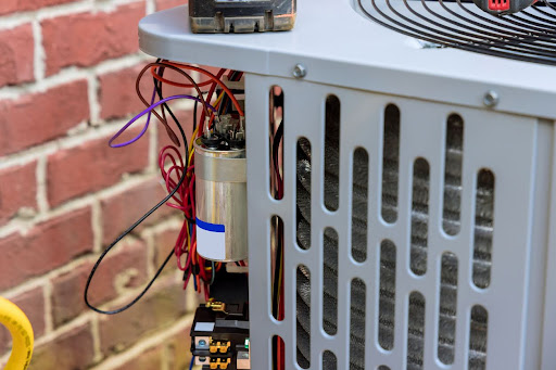Technician repairing the air conditioning unit outdoors.