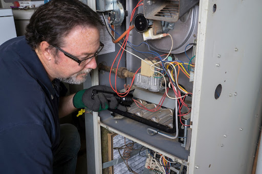 Blue Dot technician repairing heating system in Baltimore, MD