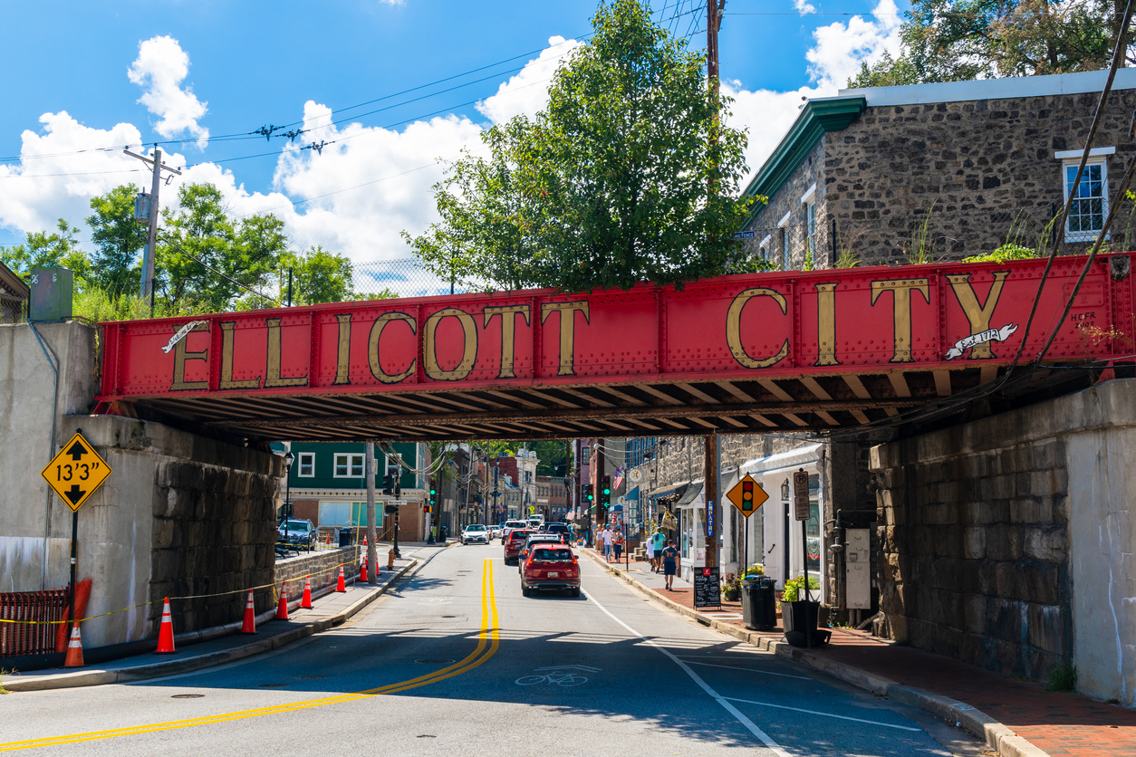 Marked by a red-painted railroad bridge, the Ellicott City Historic District lies in the valleys of the Tiber and Patapsco rivers.